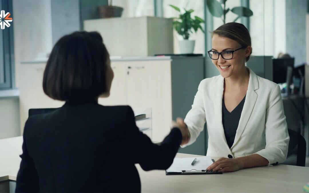 Recruiter shaking hands with a job candidate during a strategic recruiting interview in a modern office.